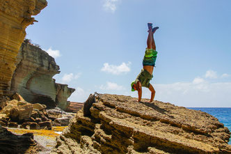  Un équilibre sur les mains près de pilliers d'Hercule, Antigua © The Antigua and Barbuda Tourism Authority