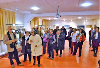 Une assistance attentive aux explications concernant l'art contemporain, traité de manière originale en marqueterie de bois