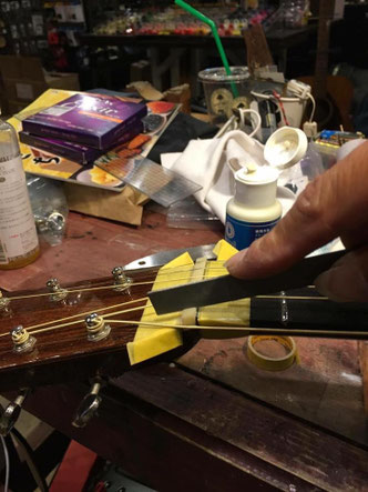 ナットにギター弦がはまる溝を掘る作業を横から見たシーン