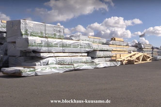 Der Blockhaus-Bausatz wartet auf Werksgelände auf den Transport zur Baustelle