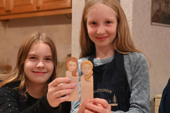 Josefine und Jule (r). zeigen ihre Porträt-Schnitzversuche. Bild: Christof Heyden