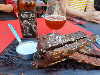 A plate of rye garlic bread with pot of cream dip and glass of beer in Riga, Latvia