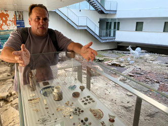 Tour guide Philip Birzulis by a glass cabinet housing archaeological artefacts in The Rocks, Sydney