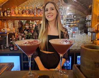 Female bartender with two pink cocktails in Riga, Latvia