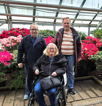 Tourists in wheelchair with tour guide in hothouse in Riga Botanical Gardens, Latvia