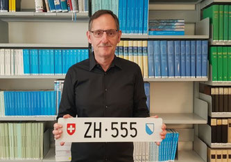 Mario Fehr hält das Kontrollschild «ZH 555» in den Händen, das bald unter den Hammer kommt.