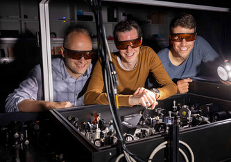 Lysander Huberich (links), Teamleiter Bruno Schuler (Mitte) und Optik-Spezialist Jonas Allerbeck an der THz-Optik, die Pikosekunden-genaue Anregungimpulse liefert. Bild: Empa