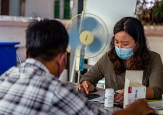 Rangun, Myanmar, am 23.04.2021: Eine Mitarbeiterin von Ärzte ohne Grenzen bereitet einen Nachschub an Medikamenten für einen Patienten vor. (c) MSF/Ben Small