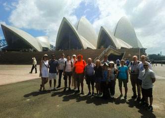 Tour group with guide in orange shirt in front of Sydney Opera House