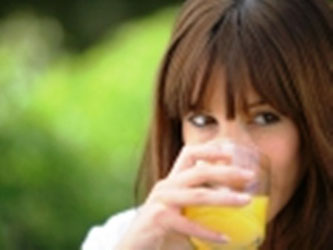 Chica bebiendo jugo de naranja.