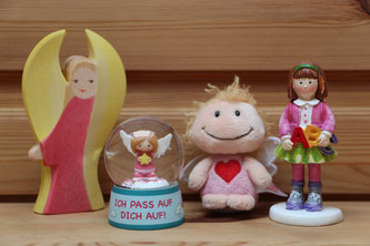 Ein Holzengel von Ostheimer, eine kleine Schutzengel-Schneekugel, ein Schutzengel-Schlüsselanhänger und eine Schulkind-Figur