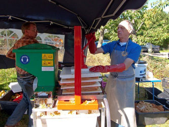 Ehrenamtliche des NABU und des Lions-Club Rinteln pressen Apfelsaft an der Apfelpresse. - Foto: Kathy Büscher