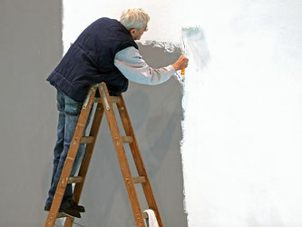 Ein älterer Herr streicht eine Wand auf der Leipziger Messe. Foto: Jan Woitas/Illustration