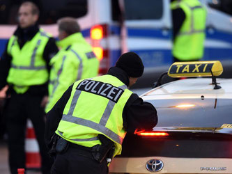 Polizeibeamte kontrollieren am Flughafen in Schönefeld ein Taxi. Nach dem Terroralarm in Chemnitz haben die Behörden die Sicherheitsvorkehrungen am Flughafen Berlin-Schönefeld erhöht. Foto: Maurizio Gambarini