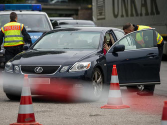 Polizisten kontrollieren an der Grenze ein Fahrzeug. Foto: Matthias Balk/Archiv