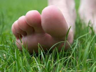 Achtsamkeitsübung für warme Tage: Langsam ein paar Schritte barfuß übers Gras gehen. Beim Aufsetzen der Füße auf das Abrollen achten und die Anspannung loslassen. Foto: Andrea Warnecke