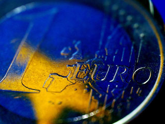 Die Fahne der Europäischen Union spiegelt sich in einer Euro-Münze. Europa schützt mit einem Notfalltopf für Pleitebanken künftig die Steuerzahler vor Milliardenkosten. Foto: Oliver Berg