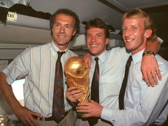 Rückflug mit Pokal: Franz Beckenbauer, Lothar Matthäus und Andreas Brehme reisen nicht mit leeren Händen von der WM ab. Foto: Wolfgang Eilmes