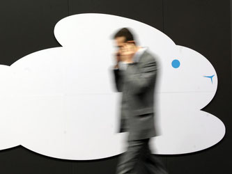 Ein Messebesucher geht an einem Cloud-Symbol vorbei. Foto: Peter Steffen/Illustration