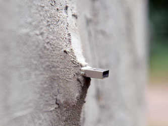 Das Ende eines USB-Sticks ragt aus einem Mauerteil der Fabeltier-Skulptur im Stadtwald Eilenriede in Hannover. Sogenannte «Dead drops» haben sich als als Kunstprojekt rund um den Globus verbreitet. Foto: Susann Prautsch