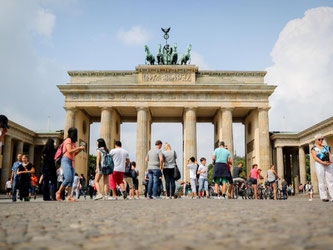 Touristen stehen in Berlin vor dem Brandenburger Tor. Foto: Kay Nietfeld