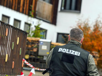 Ein Polizist geht in Georgensgmünd vor einem Haus am Tatort entlang. Foto: Nicolas Armer