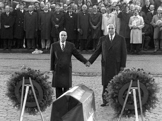 Der französische Staatspräsident Francois Mitterrand (l) und Bundeskanzler Helmut Kohl reichen sich am 22.9.1984 über den Gräbern von Verdun die Hand. Foto: Wolfgang Eilmes/Archiv