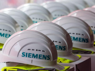 Schutzhelme mit dem Logo der Siemens AG. Der Konzern gehört zu den großen Wirtschaftsmotoren in der EU. Foto: Jens Büttner