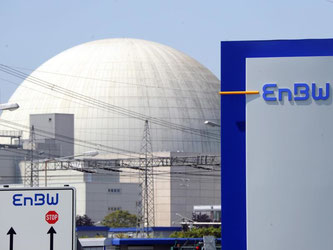Hinter einem EnBW-Logo ist das Kernkraftwerk Philippsburg zu sehen. Foto: Uli Deck/Archiv