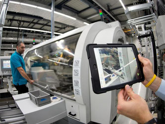 Industrie 4.0: Ein Mitarbeiter des Antriebsspezialisten Wittenstein scannt im Zahnradwerk mit einem Tablet den Barcode an einer Maschine. Foto: Bernd Weißbrod/Archiv