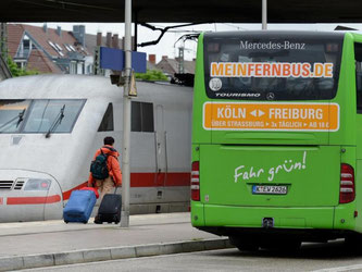 Fernbus am Bahnhof in Freiburg neben einem ICE-Zug der Deutschen Bahn. Foto: Patrick Seeger
