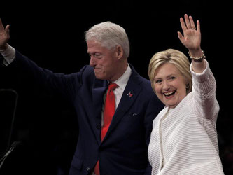 Hillary Clinton winkt zusammen mit ihrem Mann Bill ihren Anhängern zu. Foto: Peter Foley