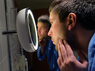 Der Blick in den Spiegel zeigt: Auch die Haut unter dem Bart braucht Pflege. Foto: Jens Kalaene