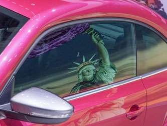 Ein Bild der New Yorker Freiheitsstatue spiegelt sich in der Scheibe eines Volkswagen Beetle. VW hat in den USA wieder Boden gut gemacht. Foto: Friso Gentsch/Volkswagen