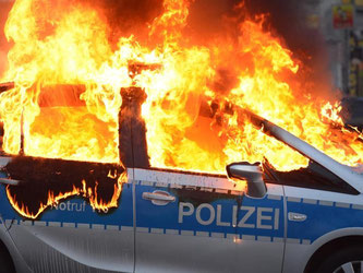 Mülltonnen und Polizeifahrzeug in Flammen: «Für uns kein "Aufwärmen", sondern eine Straftat!», twitterte die Polizei. Foto: Arne Dedert