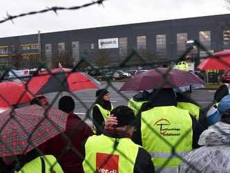 Streikende Amazon-Mitarbeiter stehen vor dem Eingang zum Amazon-Logistikzentrum im hessischen Bad Hersfeld. Foto: Uwe Zucchi