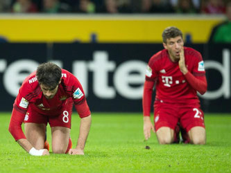 Der FC Bayern wurde auf den Boden der Tatsachen zurückgeholt: Javier Martínez (l) und Thomas Müller knien nach Abpfiff auf dem Rasen. Foto: Bernd Thissen