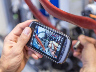 Produktion bei Bosch. Mit einem Smartphone sucht ein Mitarbeiter nach einer Störung. Foto: Daniel Maurer