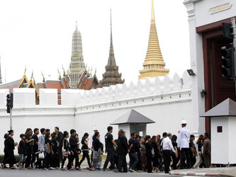 Die thailändische Bevölkerung trauert - wenn auch nicht ganz freiwillig. In Bangkok gegen Trauernde in den Großen Palast, um ein Kondolenz-Buch zu unterschreiben. Foto: Narong Sangnak