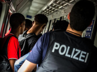 Ein Bundespolizist kümmert sich im Eurocity in Rosenheim um Flüchtlinge: Illegale Einreise muss verfolgt werden, die Justiz hat dabei keinen Ermessensspielraum. Foto: Nicolas Armer/Archiv