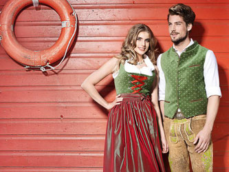 Männer tragen Beinkleid zur Tracht, etwa in auffälligem Apfelgrün (Dirndl ca. 229 Euro, Samtweste ca. 149 Euro, Lederhose 1198 Euro, Socken 25 Euro maschinengestrickt und 109 Euro handgestrickt). Foto: Angermaier Trachten