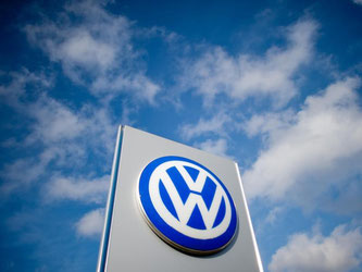Ein Schild mit einem Volkswagen Logo steht vor einem VW-Autohaus in Hannover. Foto: Julian Stratenschulte/Illustartion