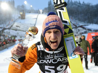 Severin Freund jubelt nach seinem Sieg mit Trophäe. Foto: Uwe Zucchi