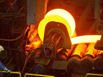 Eine glühende Stahlrolle im Warmwalzwerk der ArcelorMittal Eisenhüttenstadt GmbH in der brandenburgischen Stadt. Foto: Patrick Pleul