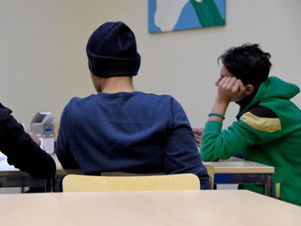 Drei Jugendliche Flüchtlinge sitzen an einem Tisch. Foto: Carsten Rehder/Archiv