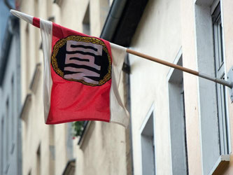 NPD-Fahne an der Parteizentrale in Berlin: Die Verfassungsrichter erwarten zusätzliche Belege für die antidemokratische Haltung der rechtsextremen Partei. Foto: Maurizio Gambarini/Archiv
