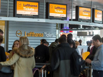 Der Streik geht weiter: Reisende warten vor einem Schalter der Lufthansa auf dem Flughafen in München. Foto: Matthias Balk
