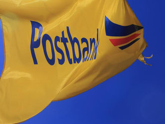 Die gelbe Flagge mit dem Schriftzug «Postbank» vor einer Filiale in Magdeburg. Foto: Jens Wolf