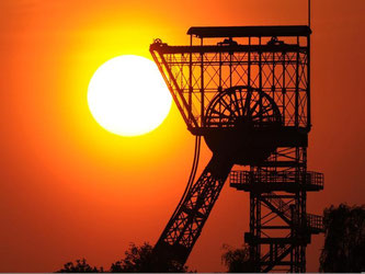 Die Sonne geht hinter dem Förderturm der Zeche Zollern in Dortmund unter. Foto: M. Becker/Archiv