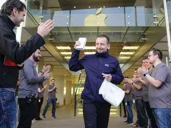 Der erste Käufer eines neuen iPhone 6S verlässt unter Applaus der Store Mitarbeiter in Hamburg den Apple-Store. Foto: Axel Heimken